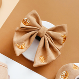 Pawtisserie Sailor Bow Tie by Cocopup London angled on a white plate with pastry embroidery visible