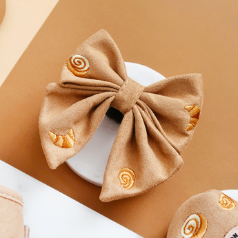 Pawtisserie Sailor Bow Tie by Cocopup London angled on a white plate with pastry embroidery visible