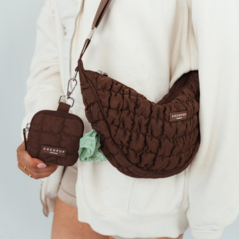 Person wearing quilted espresso walking bag and holding matching Crescent treat pouch