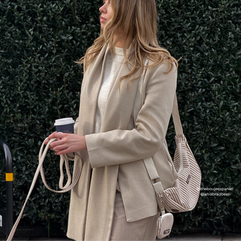 Woman outdoors holding the coiled London Linen Stripes lead with a matching shoulder bag, by Cocopup London