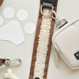 Brown Aviator strap clipped to a cream Cocopup London bag, showing silver ring and clasp