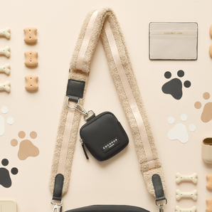 Teddy Rupert bag strap attached to a small black Cocopup London bag in a flat lay