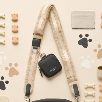 Teddy Rupert bag strap attached to a small black Cocopup London bag in a flat lay