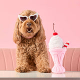 Dog sitting beside the Strawberry Milkshake interactive toy
