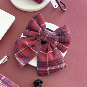 Cocopup London Mulberry Plaid Sailor Bow Tie angled on a white dish in a mulberry flat lay