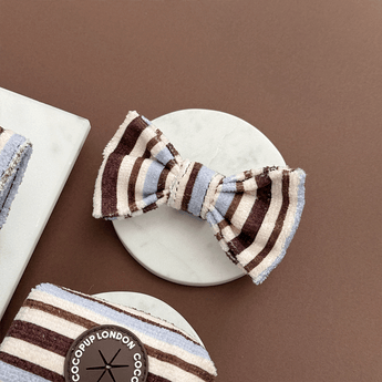 Brown & Blue Stripes bow tie angled on a stone tile beside matching accessories