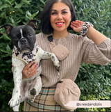 Woman wearing the Teddy Rupert treat pouch and matching walking bag while holding a small dog