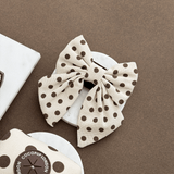 Tiramisu Polka Dot Sailor Bow Tie by Cocopup London in a neutral flat lay