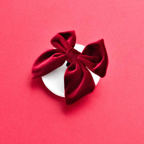 Cocopup London Berry Red Luxe Velvet Sailor Bow Tie on a bright red background