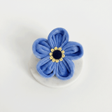Cocopup London Forget Me Not Collar Flower in blue velvet with a yellow and black centre on white