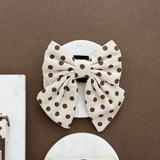 Vooraanzicht van de Tiramisu Polka Dot hondenstrik in een flatlay