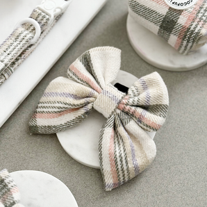 Oxford Plaid Sailor Bow Tie by Cocopup London arranged on a white plate