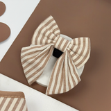 London Linen Stripes Sailor Bow Tie angled in a neutral brown flat lay, by Cocopup London