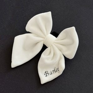 Cocopup London White Luxe Velvet Sailor Bow Tie on a dark background with personalisation on one tail