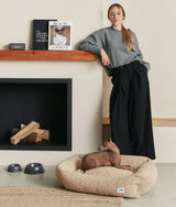 Small dog resting in a beige fleece CAFIDE Snozy dog bed