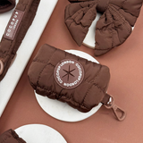 Cocopup London Espresso Quilted Poop Bag Holder angled in a brown accessories flat lay