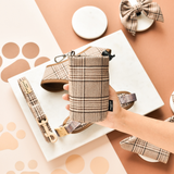 Hand holding Pup Plaid drawstring treat pouch in a flat lay with matching accessories