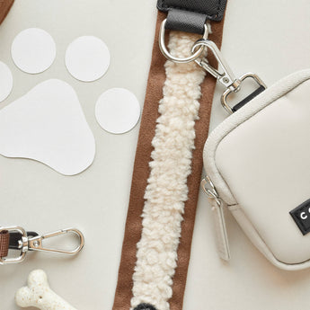 Brown Aviator strap clipped to a cream Cocopup London bag, showing silver ring and clasp