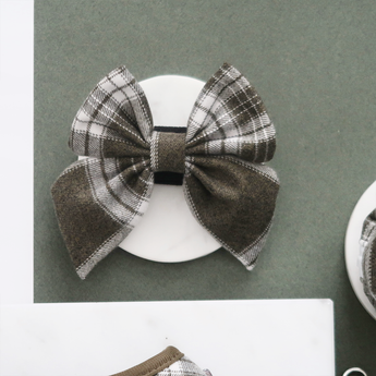 Front view of the Cocopup London Olive Check Sailor Bow Tie on a white dish