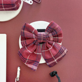 Front view of the Cocopup London Mulberry Plaid Sailor Bow Tie on a white dish