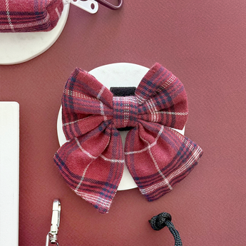 Front view of the Cocopup London Mulberry Plaid Sailor Bow Tie on a white dish