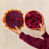 Hands opening the Berry Pie snuffle dog toy to reveal its treat-searching base