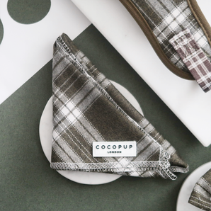 Front view of the folded Cocopup London Olive Check Bandana with the brand label visible