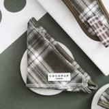 Front view of the folded Cocopup London Olive Check Bandana with the brand label visible