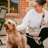 Vrouw wandelt buiten met een bruine krulhond in het Teddy Rupert tuig