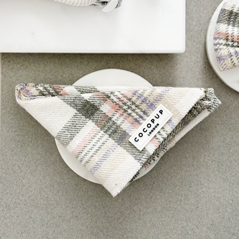 Vooraanzicht van dichtbij van de gevouwen Cocopup London Oxford Plaid Bandana in een neutrale flatlay met accessoires