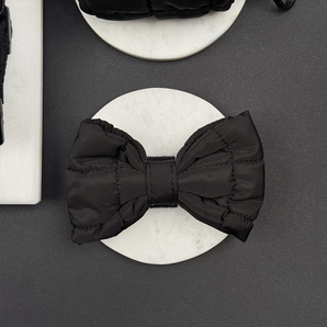 Front view of the Cocopup London Onyx Quilted Bow Tie on a white dish
