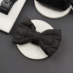 Cocopup London Onyx Quilted Bow Tie angled on a white dish in a black flat lay