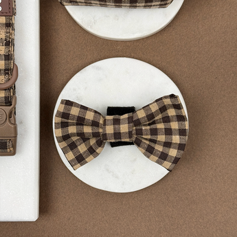 Cotswolds Check dog bow tie displayed front-on on a round stone tile