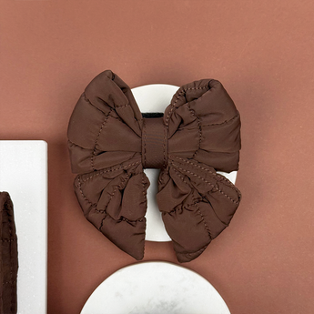 Front view of the Cocopup London Espresso Quilted Sailor Bow Tie on a white dish