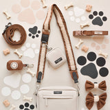 Brown Aviator strap styled with cream dog-walking bags and matching brown accessories