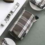 Olive Check drawstring treat pouch angled in a flat lay with matching collar and accessories