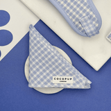 Cocopup London English Blue Bandana gevouwen op een wit schaaltje in een blauwe flatlay